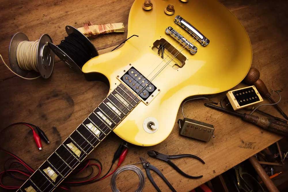 Les Paul Gold Top sur l'établi avec micros, pinces et fer à souder